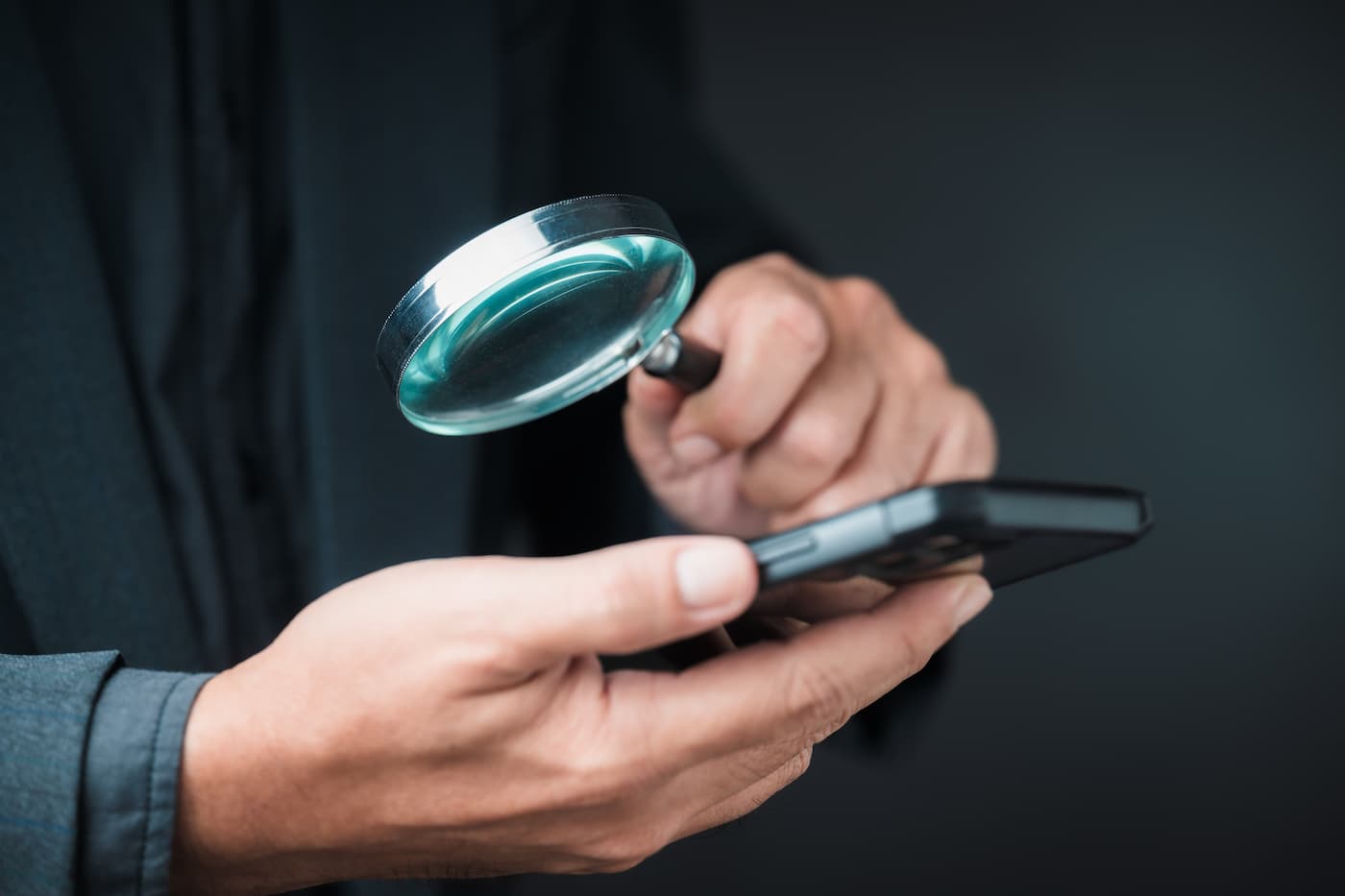 Eine Lupe über einem Smartphone als Symbolbild für die KI Konsum Studie