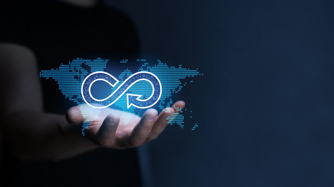 Eine offene Hand mit einer digitalen Weltkarte und dem Kreislaufwirtschaftszeichen