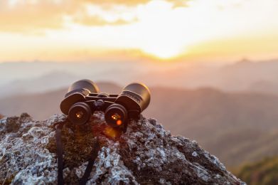 Ein Fernglas auf einem Berg liegend als Symbolbild für Gartners Vorhersage für CCOs & PR Agenturen